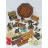A large selection of vintage chess pieces, draught pieces, dominoes in ivory and turned wood,