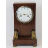 A mahogany table clock decorated with twin sphinx to the base,