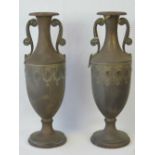 A pair of 20th century brass vases of Romanesque form having side handles and embossed design to