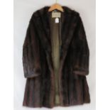A musquash fur coat, bears label for The Canadian Fur Company, overall length 96cm,