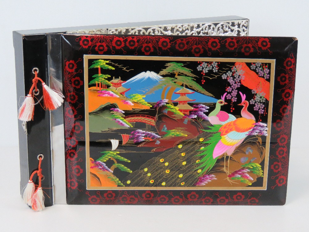 A vintage Japanese black lacquer musical photograph album having hand painted scene upon with