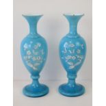 A pair of blue white cased art glass vases having handpainted white flowers upon, a/f,