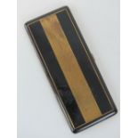 A French Art Deco black enamel cigarette case having engine turned geometric pattern to front,