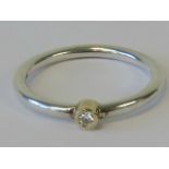 A silver and diamond Pandora ring having single round cut brilliant diamond in yellow metal setting