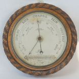 A carved oak Victorian aneroid barometer