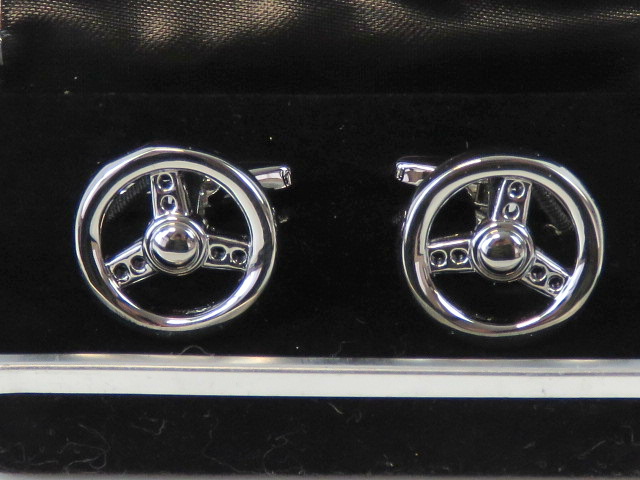 A pair of as new steering wheel cufflink