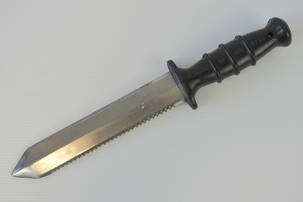 A Royal Navy Divers knife having saw back and rubberised grip, stamped NSN 64220 99 523 9744,