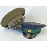 Two Russian military peaked caps having makers labels within.