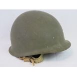 A US WWII M1 Infantry issue helmet with original liner and chinstrap having plain olive drab paint,