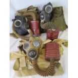 Three WWII British Military gas masks in original canvas carry bags with filters and hoses.