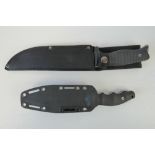 Two modern combat knives with sheaths.