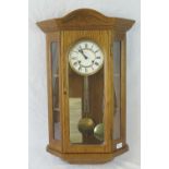 A contemporary oak cased eight day sticking wall clock by Hermle, 68cm high.