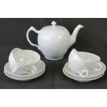 A Royal Copenhagen ivory ground teapot together with four matching cups and saucers.