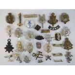 A quantity of assorted military cap and epaulette badges including; REME, Royal Scots,