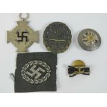 A reproduction 'black' WWII German Wound badge, together with a medal, pin badge and cloth badge.