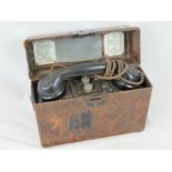 A WWII German Wehrmacht field telephone in bakelite case with instructions and receiver.