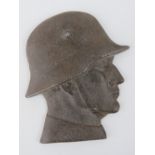 A metal plaque in the form of a WWII German soldier in helmet, 13 x 11cm.