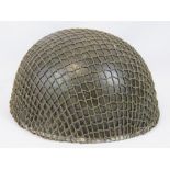 A WWII British Para Troopers helmet with scrim netting,