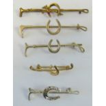 A stock pin or brooch having fox and horse shoe over riding crop bar,