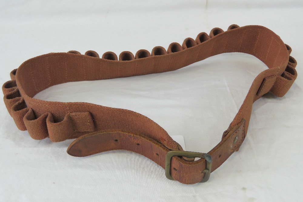 A vintage canvas and leather 12 gauge cartridge belt having brass buckle.