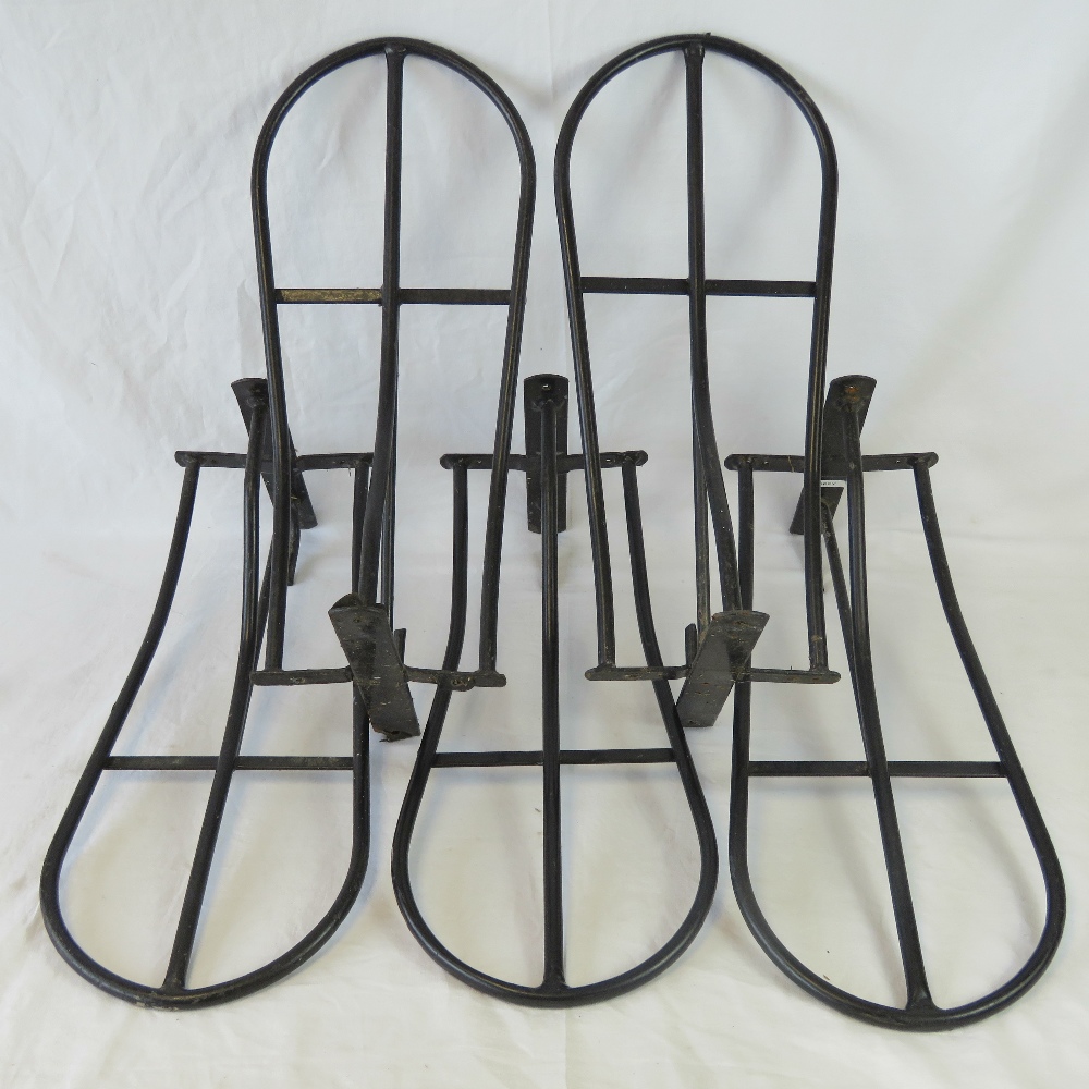 A pair of black painted saddle hooks and two matching red painted saddle hooks.