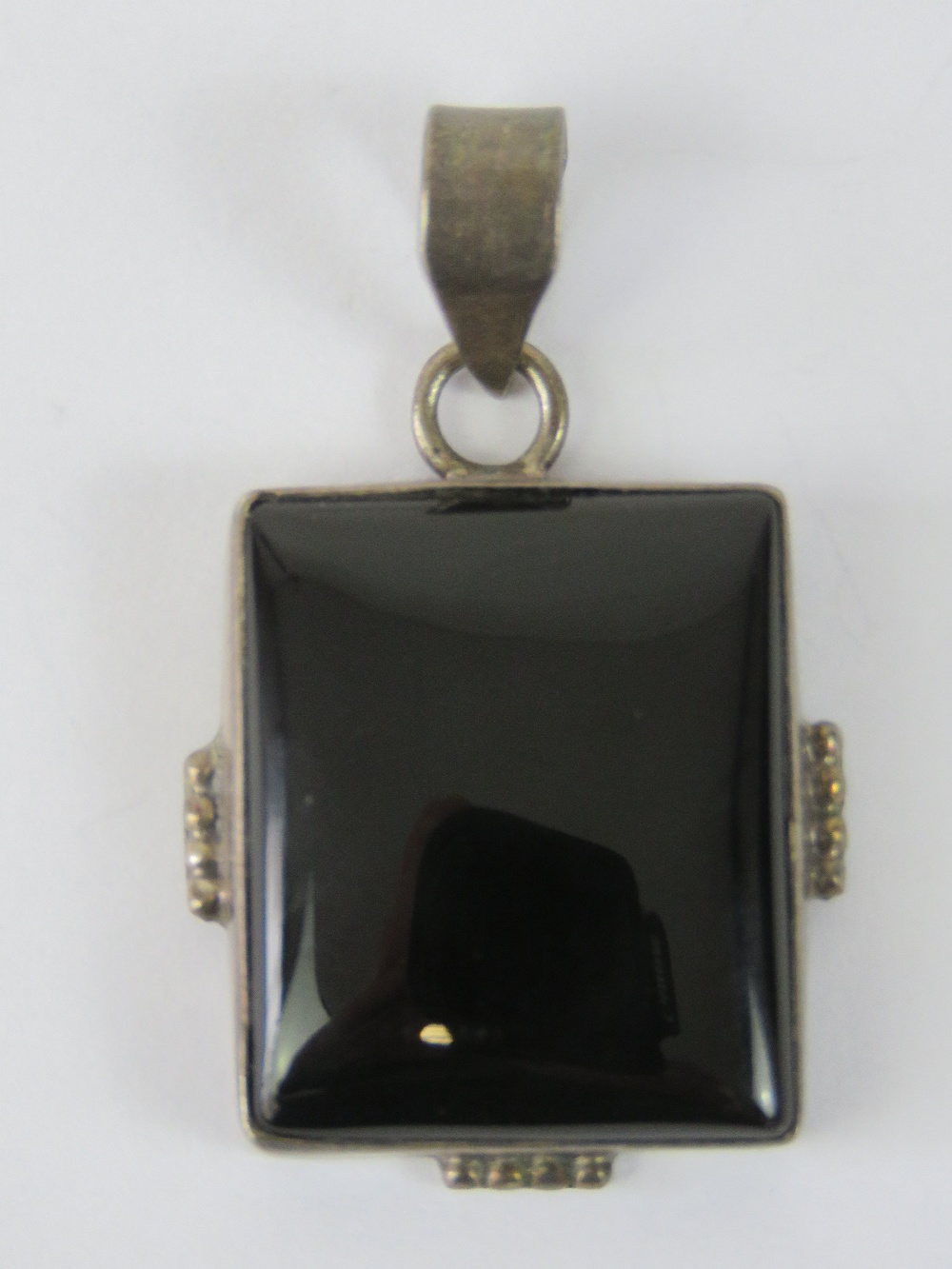 A rectangular onyx cabachon in silver pe