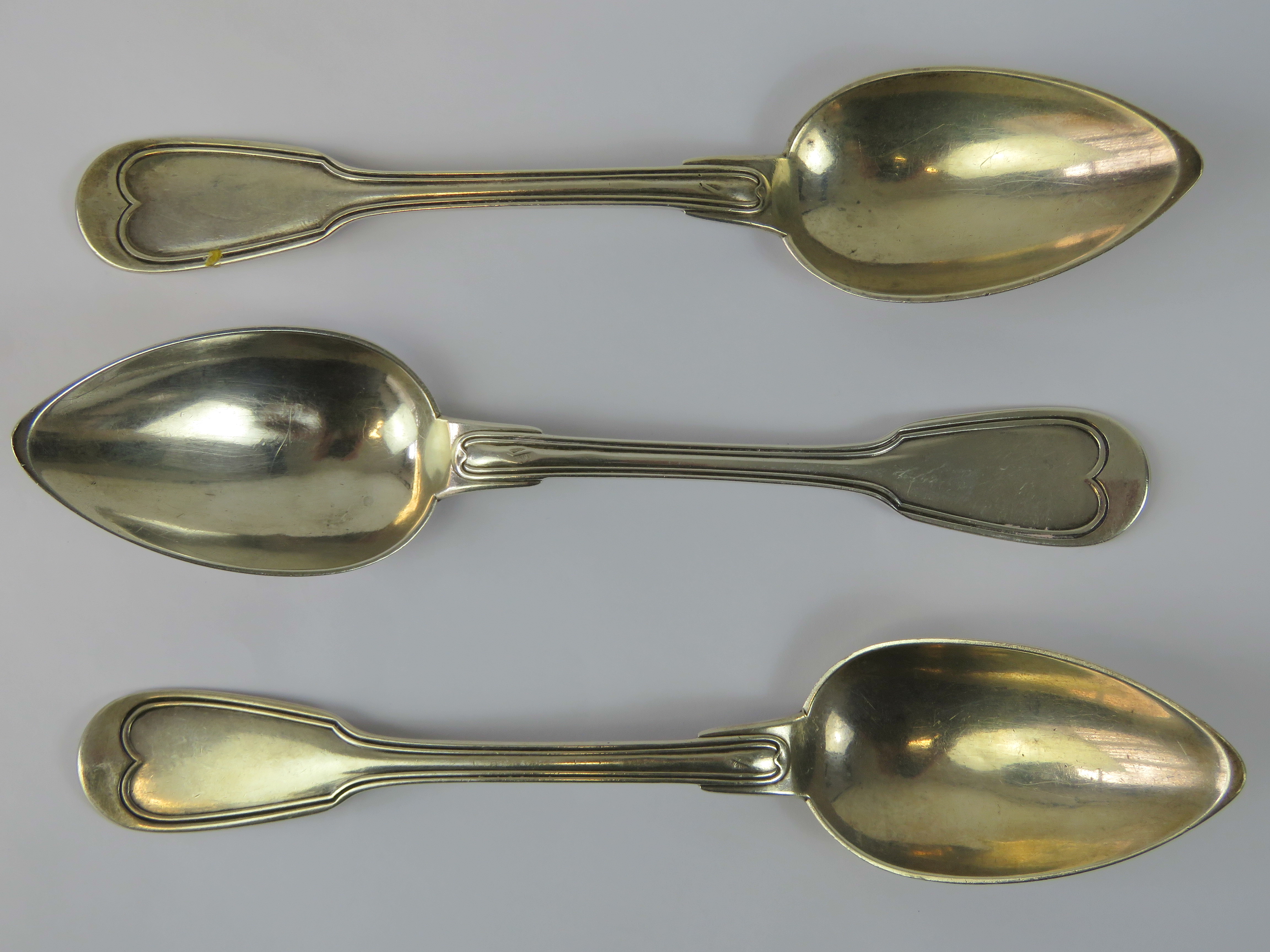 Three silver serving spoons marked Bunet