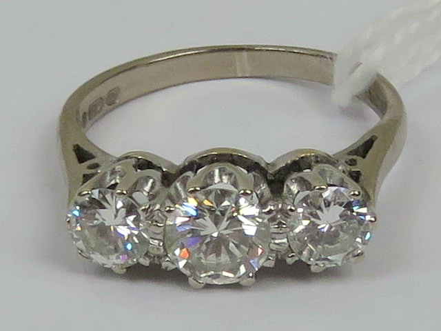 An 18ct white gold and diamond three stone ring, the central round cut diamond approx 0.