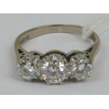 An 18ct white gold and diamond three stone ring, the central round cut diamond approx 0.