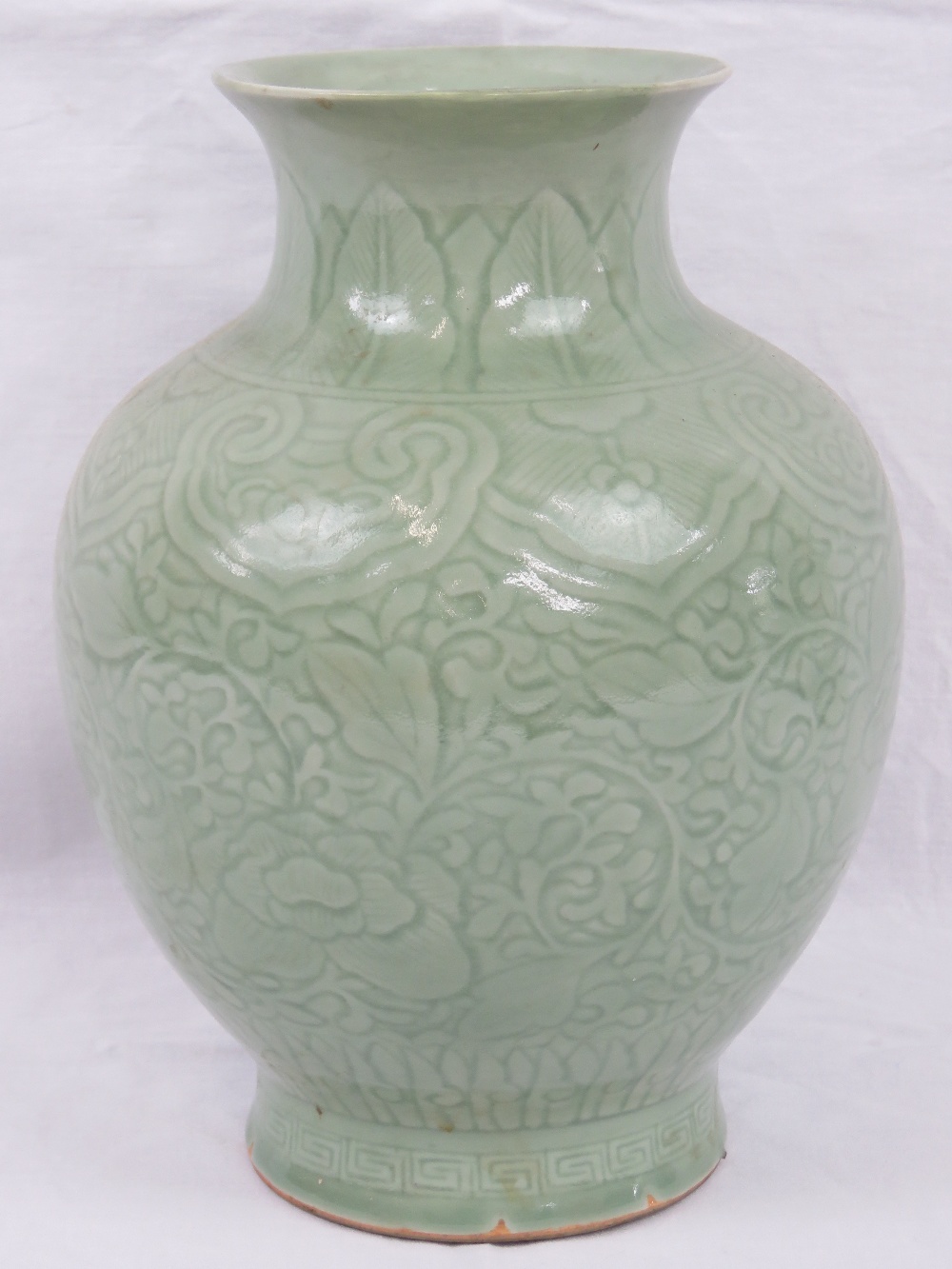 A Republican Chinese celadon green ovoid vase with foliate scrolls, flower heads and lappet border,