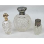 Three cut glass perfume bottles; one of round form having HM silver lid,