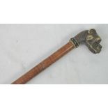 A walking cane in faux walnut having cast brass mastiff head complete with faceted garnet eyes,