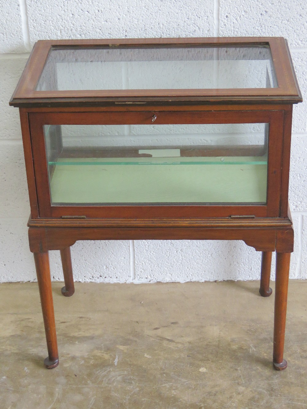 A delightful Edwardian glass and mahogany bijouterie table having satin lined base and single glass