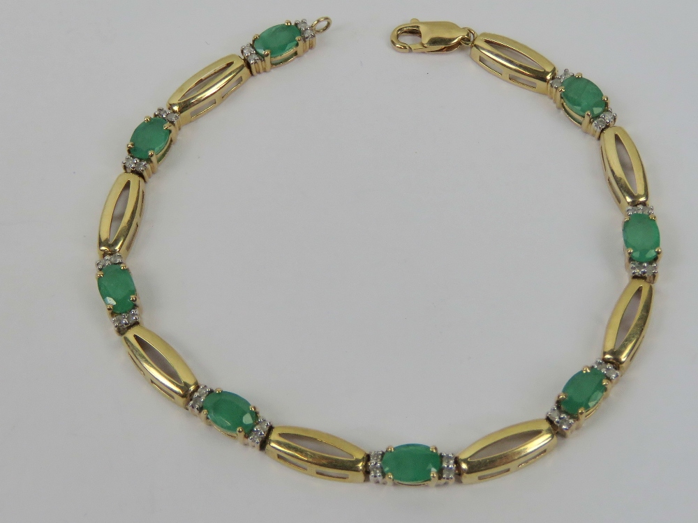 A 10ct gold diamond and emerald bracelet having eight oval cut emeralds with pairs of diamonds