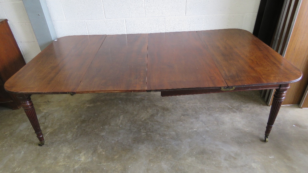 A 19th century mahogany pull out extending dining table having two leaves raised over reeded legs