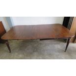 A 19th century mahogany pull out extending dining table having two leaves raised over reeded legs