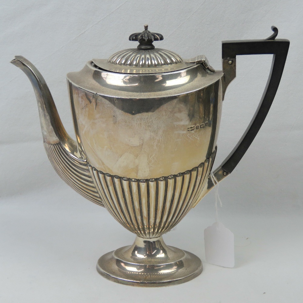 A HM silver coffee pot having gadrooned body and ebonised handle,