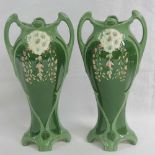 A pair of Eichwald Art Nouveau two handled vases decorated with flower heads in relief and trailing