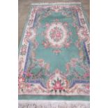 A good Oriental Famille Vert green ground rug with floral decoration throughout,