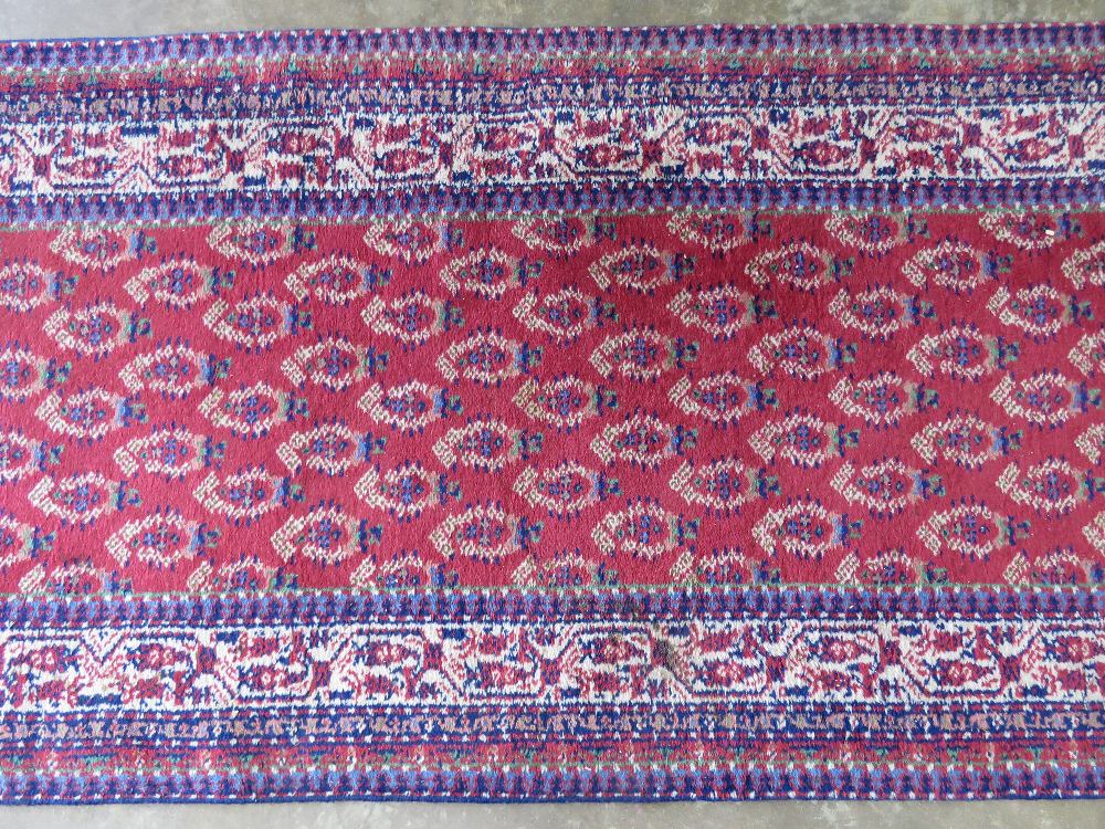 A red ground woollen runner having geometric pattern upon, measuring 350 x 92cm. - Image 2 of 2