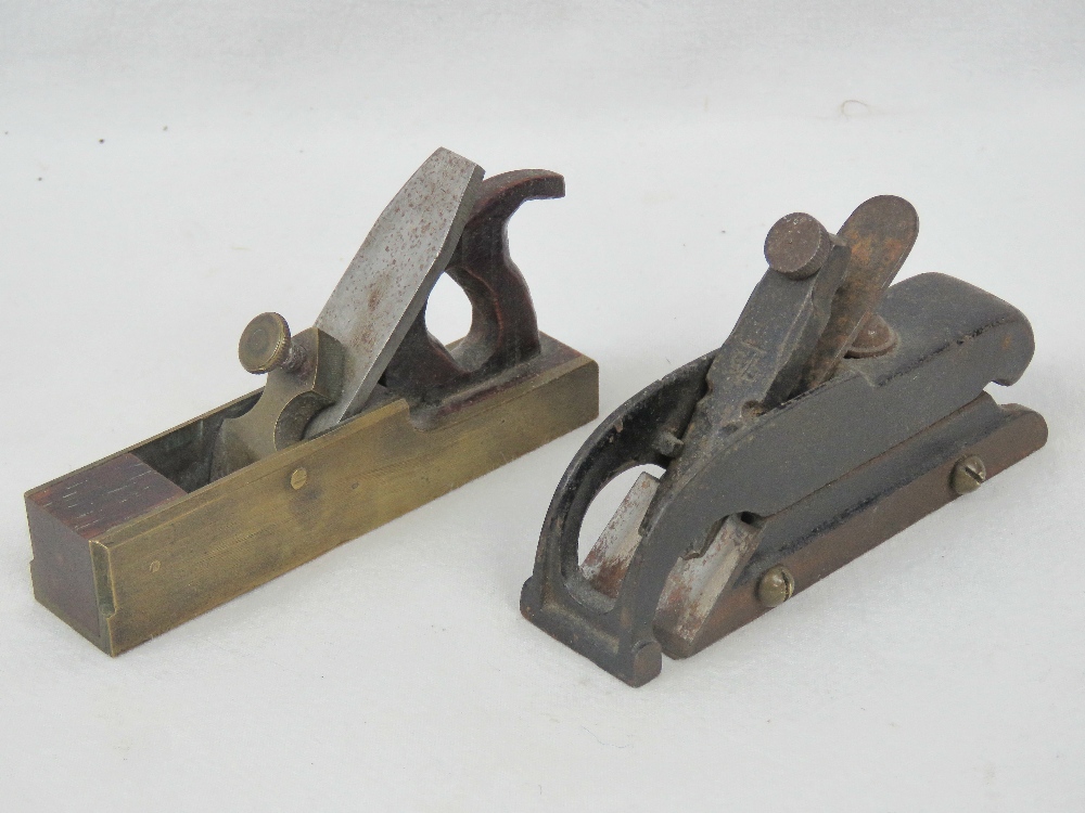 An antique miniature gun metal block plane, base plate 10cm, with wooded case,