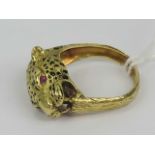 An unusual 18ct gold leopards head ring having black enamel spots and faceted garnet eyes,