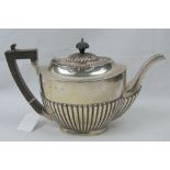 A HM silver teapot having gadrooned body and ebonised handle,