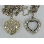 A silver heart shaped pendant having white stone border and glass central panel,
