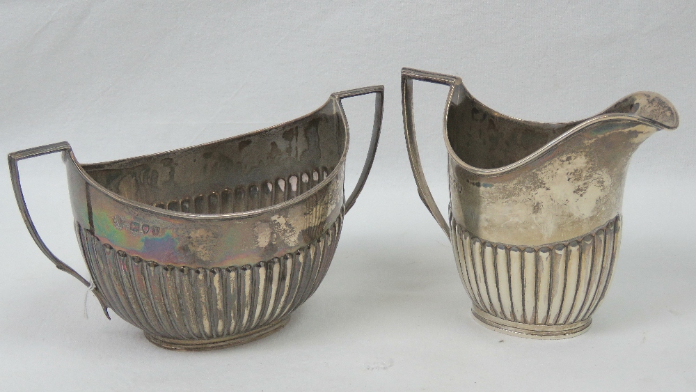 A HM silver jug and sugar bowl set having gadrooned bodies and geometric handles,