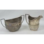 A HM silver jug and sugar bowl set having gadrooned bodies and geometric handles,