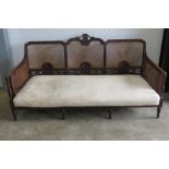 A three seater bergere settee raised over six legs, cane work a/f,