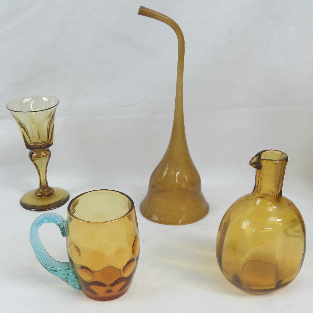 Four amber glass items; bottle, tankard, glass, and wine funnel.