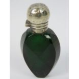 An emerald glass perfume bottle having clear glass stopper and HM silver lid (lid a/f),
