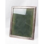 A large HM silver photograph frame of plain form having leatherette easel back,